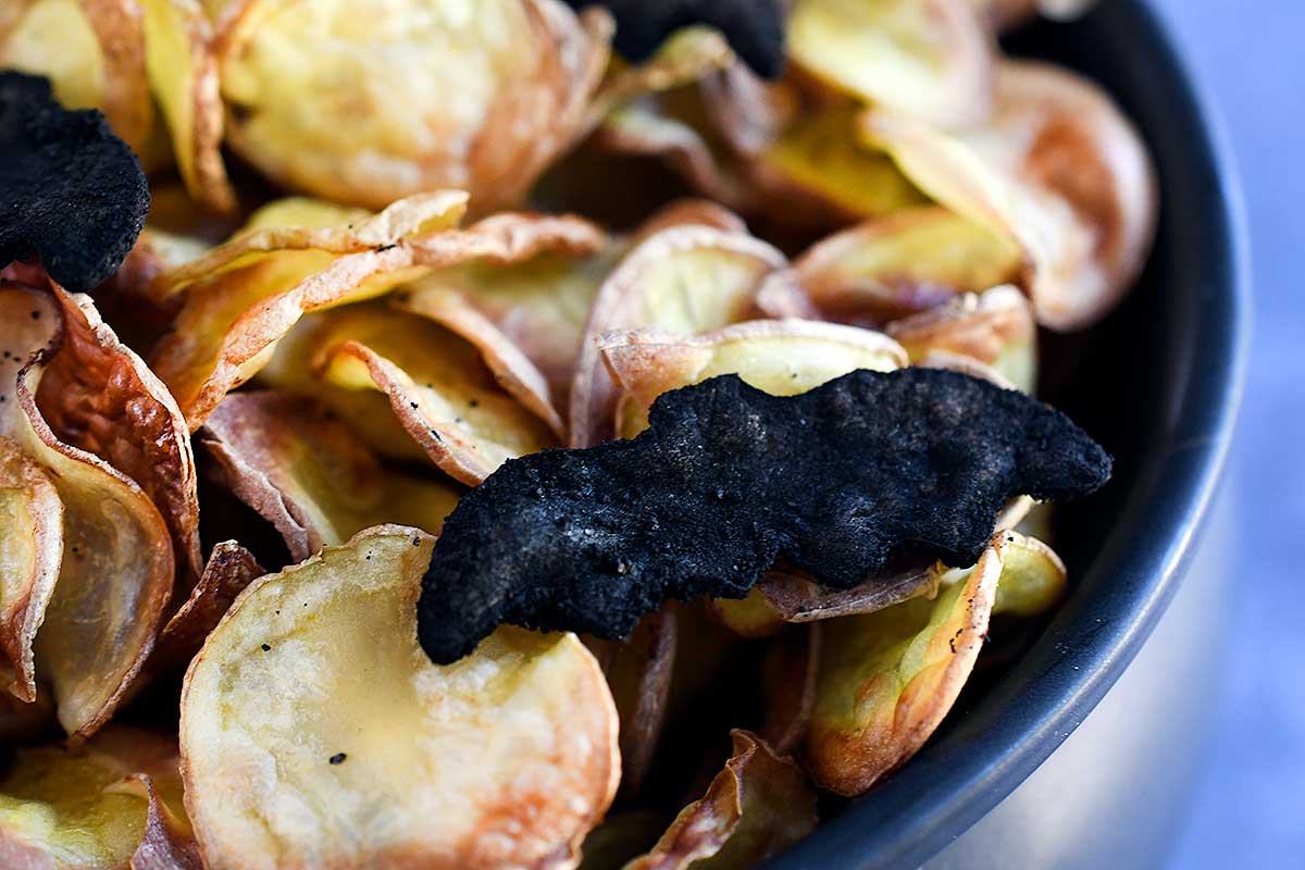 Bat chips coated in black seasoning mix (see in post for recipe) on top of yellow chips.