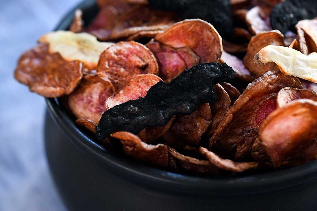 Bat chips coated in black seasoning mix (see in post for recipe) on top of red potato chips.