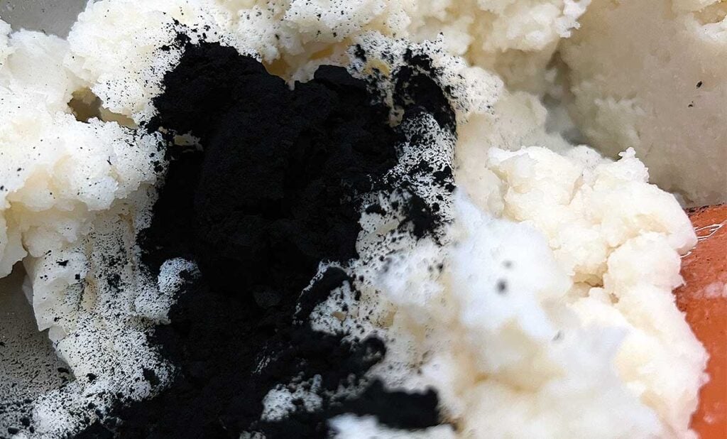 Food grade charcoal powder being added to the mashed potatoes and flour.